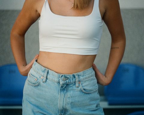 woman in white tank top and blue denim jeans