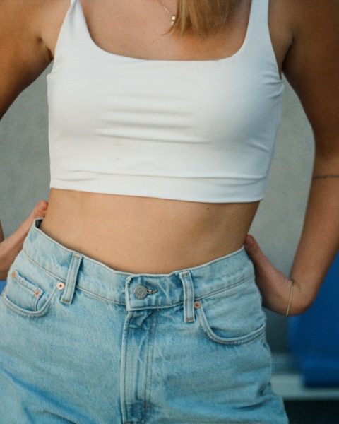 woman in white tank top and blue denim jeans