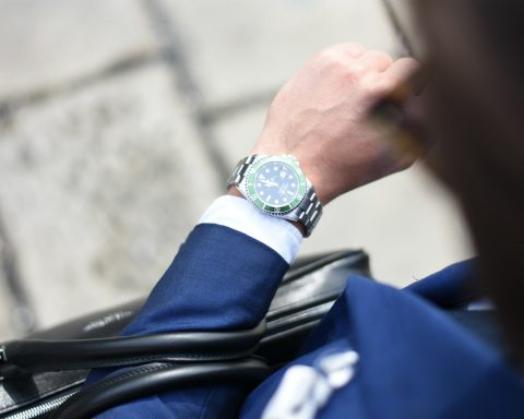 person looking at silver-colored analog watch