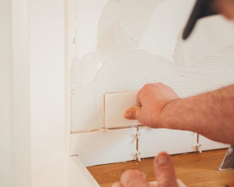 person pressing white wall