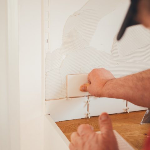 person pressing white wall