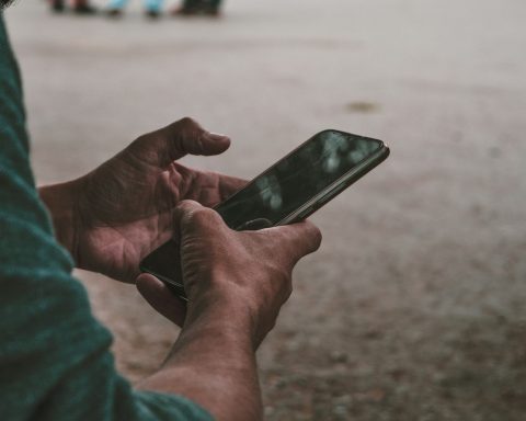 a person holding a cell phone in their hands