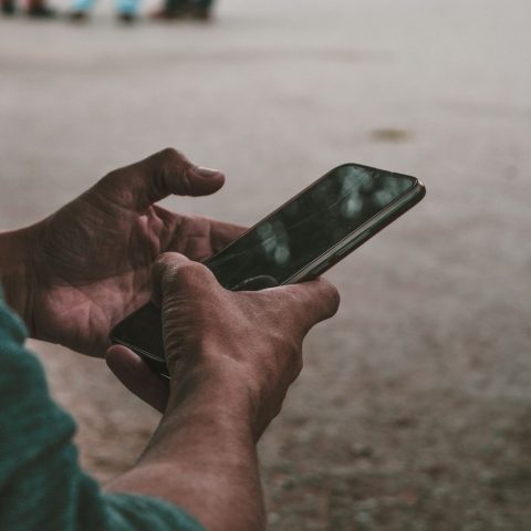 a person holding a cell phone in their hands