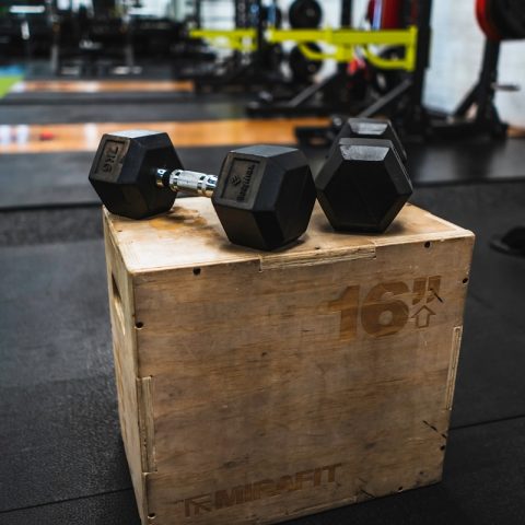 black and gray dumbbells on brown wooden crate
