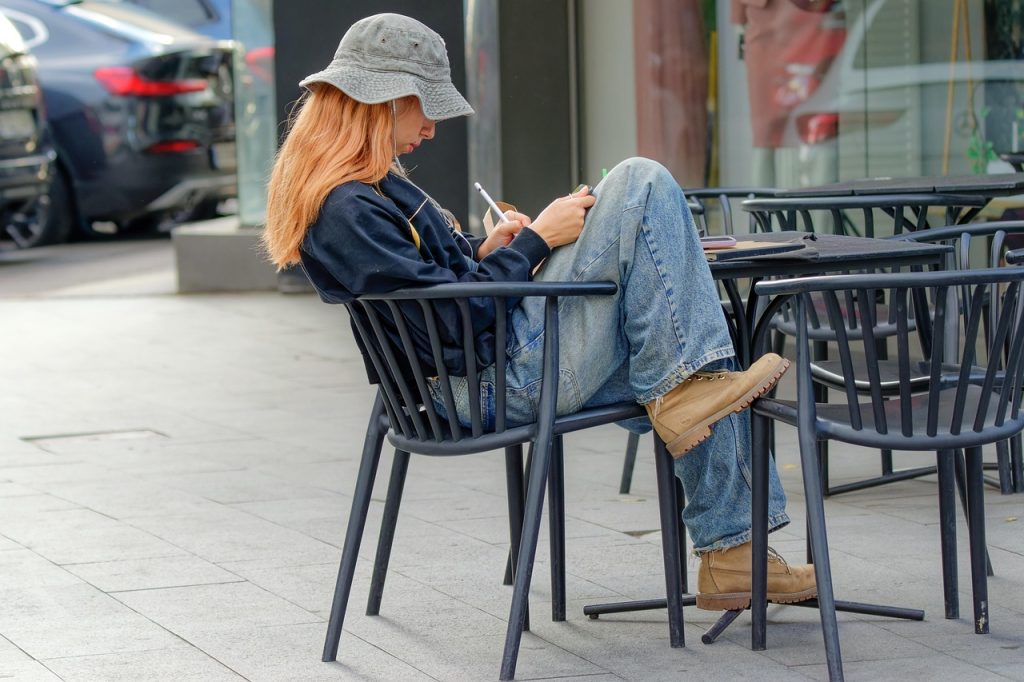 Persoon zit op een terras met een notitieboek en denkt na over een carrièreswitch in de zomer