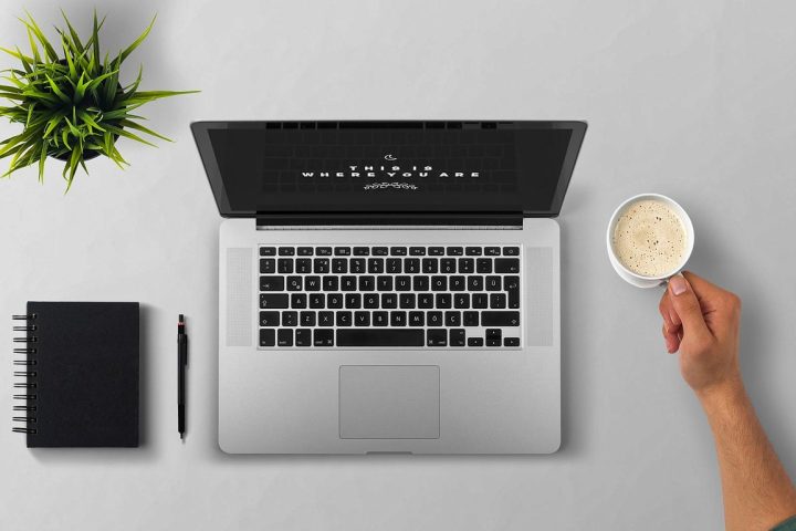 Persoon die aan een laptop werkt in een koffiebar als freelancer