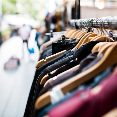 Een kledingrek met genderneutrale kleding in neutrale tinten
