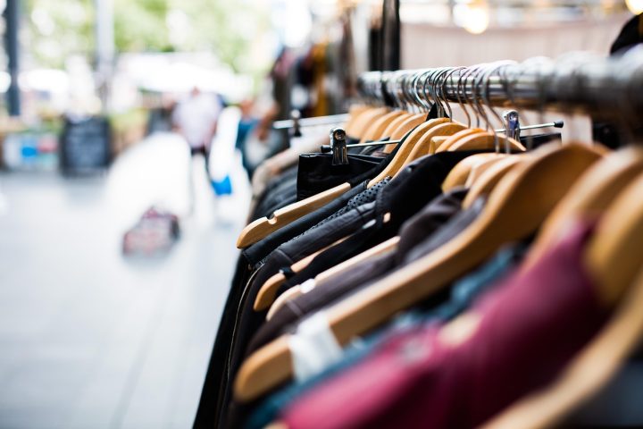 Een kledingrek met genderneutrale kleding in neutrale tinten