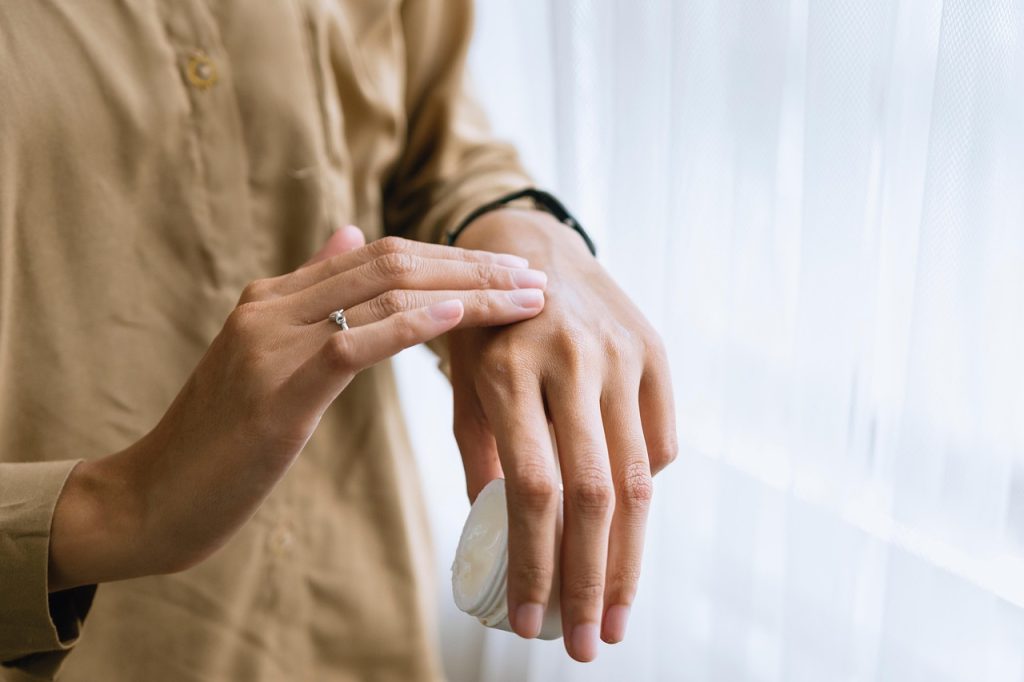 Persoon die 's ochtends rustig gezichtscrème aanbrengt als onderdeel van een verzorgingsritueel