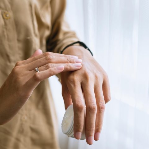Persoon die 's ochtends rustig gezichtscrème aanbrengt als onderdeel van een verzorgingsritueel
