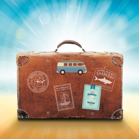 Toilettas met zonnebrand en verzorgingsproducten klaargelegd voor een zomervakantie