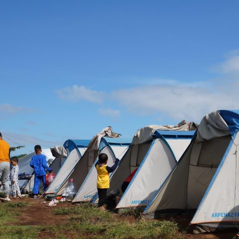 Een vrouw zet alleen haar tent op bij een festival camping