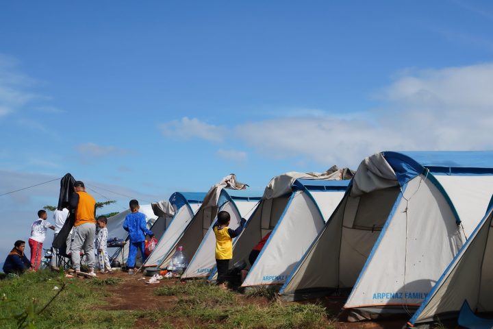 Een vrouw zet alleen haar tent op bij een festival camping