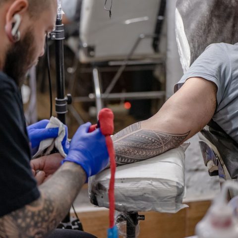 Close-up van een genezende tattoo op de onderarm met lichte schilfering en kleurpatronen