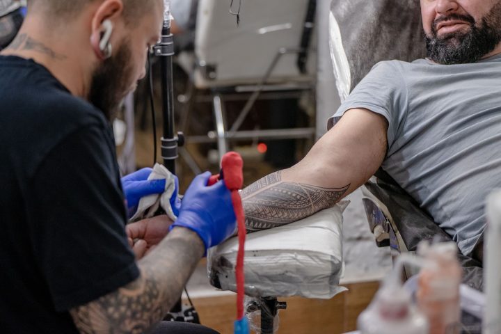 Close-up van een genezende tattoo op de onderarm met lichte schilfering en kleurpatronen