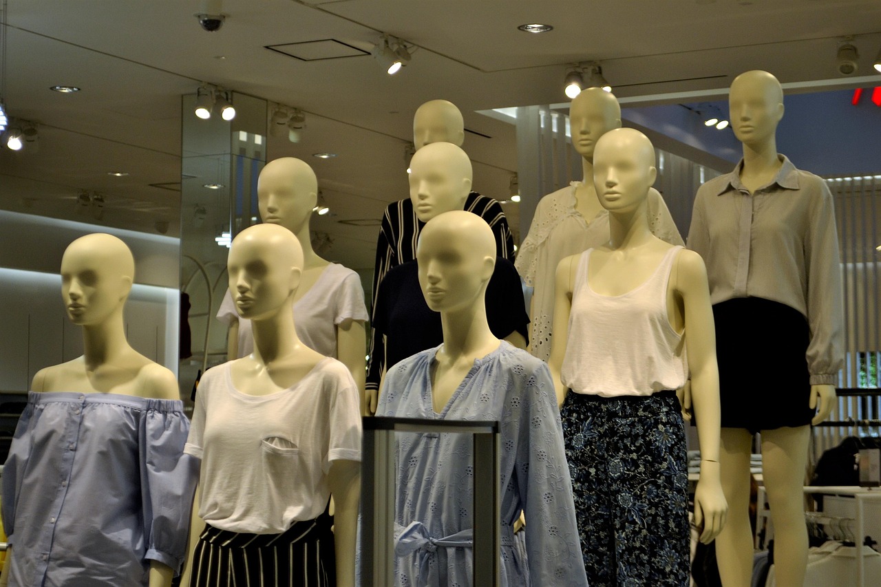 Vrouw past een gekleurde blouse in een paskamer en bekijkt zichzelf in de spiegel
