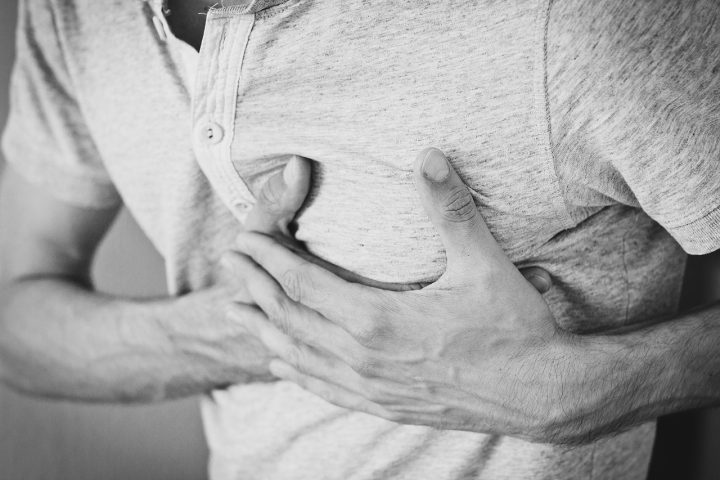 Persoon zit rustig met handen op de borst en oefent een lichaamsscan