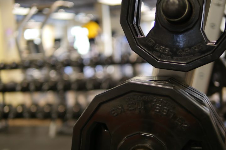 Vrouw die gewichten heft in de sportschool tijdens een krachttraining