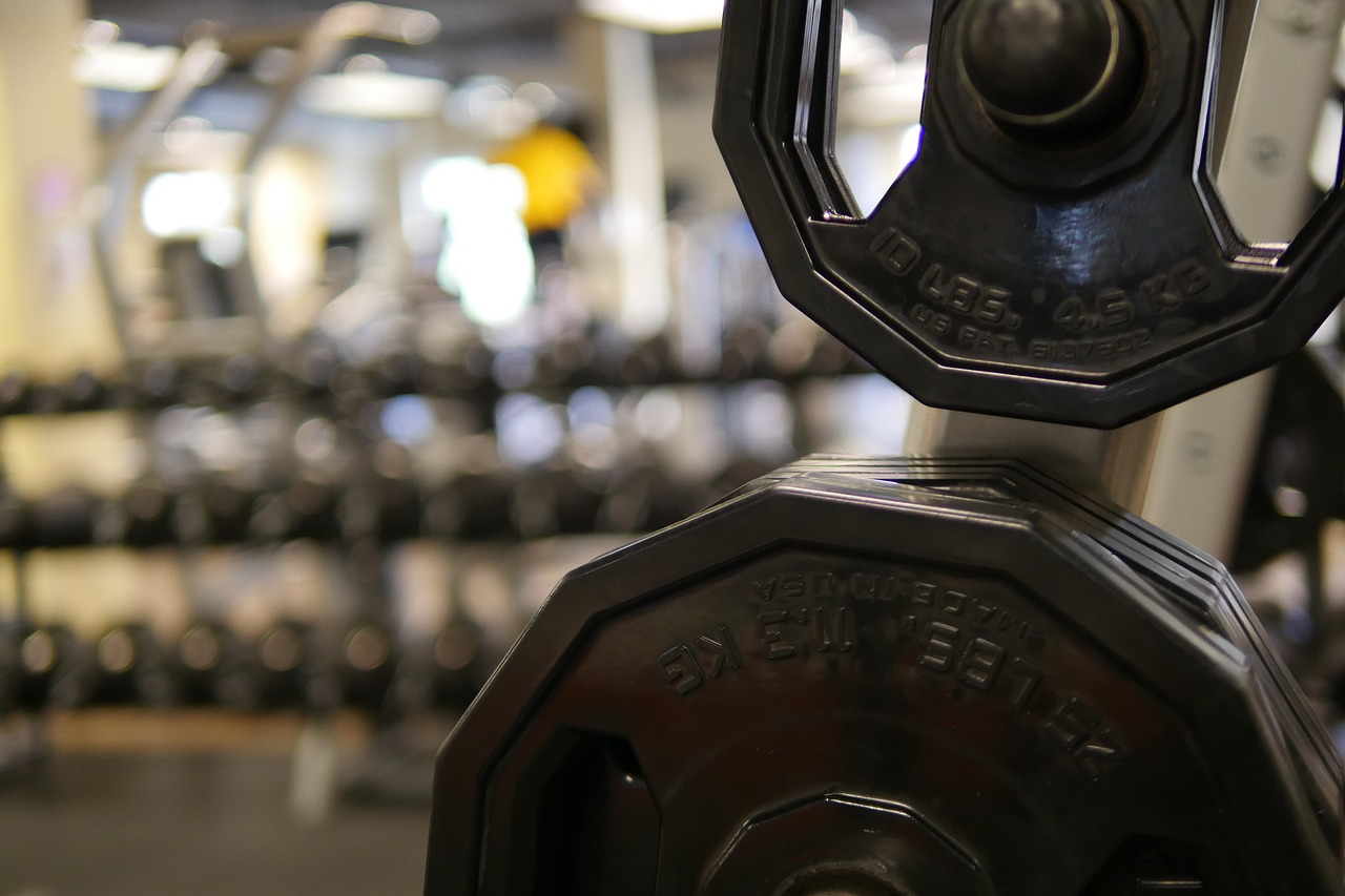 Vrouw die gewichten heft in de sportschool tijdens een krachttraining