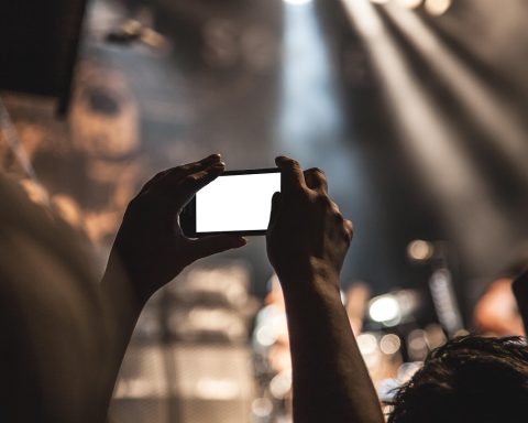 Bovenaanzicht van kleding op een lichte ondergrond tijdens het fotograferen met een smartphone