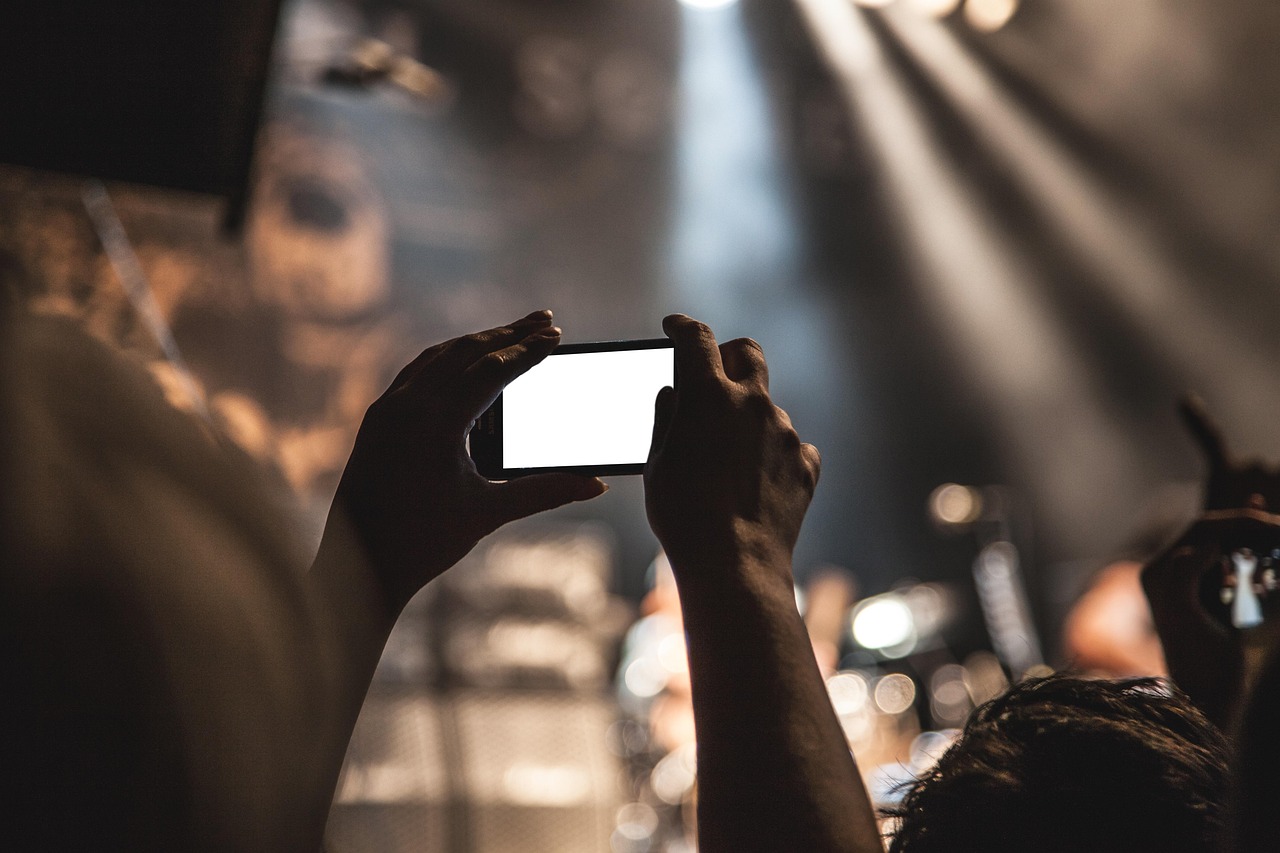 Bovenaanzicht van kleding op een lichte ondergrond tijdens het fotograferen met een smartphone