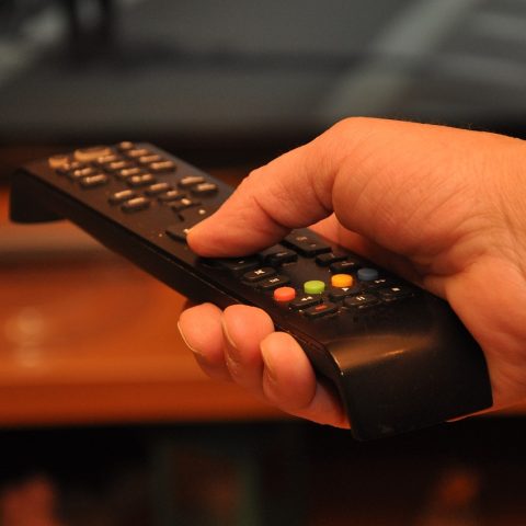 Persoon die 's avonds in het donker naar een serie kijkt op de televisie