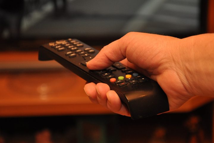 Persoon die 's avonds in het donker naar een serie kijkt op de televisie